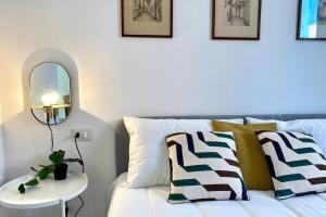 - un canapé blanc avec un miroir et une table dans l'établissement Borgio Verezzi, Mare, Natura e Relax, à Borgio Verezzi