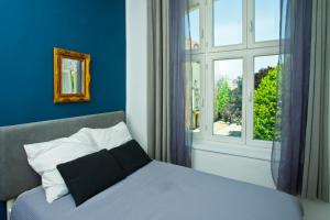 a blue bedroom with a bed and a window at Kamienica Monte Cassino Sun I 7 min plaża I 2 sypialnie I Balkon in Sopot