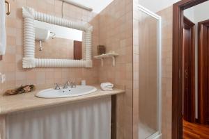 a bathroom with a sink and a mirror at Casa Gallasso in Santa Teresa Gallura +28 photos
