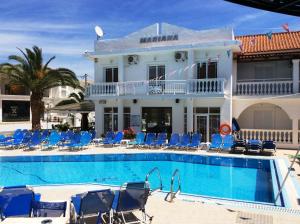a hotel with a swimming pool and chairs and a building at Mariana Hotel in Laganas