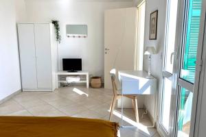 Dieses weiße Zimmer verfügt über einen Schreibtisch und einen Computer. in der Unterkunft Terrazza Vista Mare in Borgio Verezzi