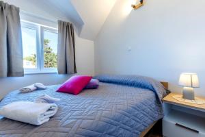 a bedroom with a bed with purple and pink pillows at Balkun in Maslinica