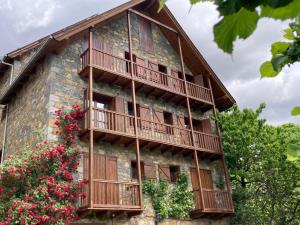 a building with wooden balconies and flowers on it at Casa Planominguero in Taull