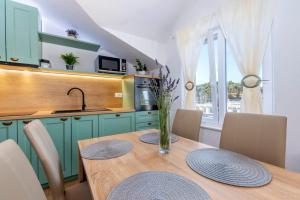 uma cozinha com uma mesa com cadeiras e um lavatório em Balkun em Maslinica
