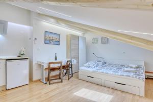 a white bedroom with a bed and a table at Apartment light in Pula in Pula