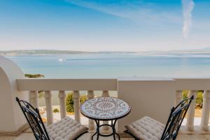 a table and chairs on a balcony with a view of the ocean at Hotel Miramare in Crikvenica