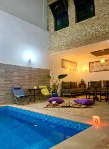 a living room with a swimming pool and a couch at Riad Zahraa Al Ismailia in Meknès
