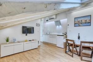 a kitchen with white cabinets and a dining table at Apartment light in Pula in Pula
