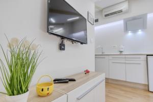 a white kitchen with a tv on a wall at Apartment light in Pula in Pula