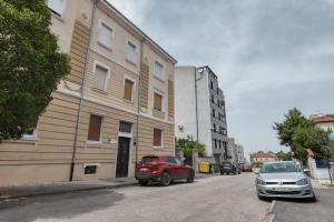 two cars parked on a street next to a building at Apartment light in Pula in Pula