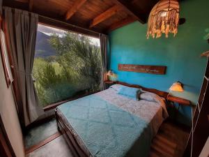a bedroom with a bed and a large window at Cabañas Las Nativas in Lago Puelo
