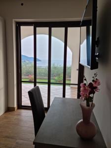 Qvattro stagioni panoramic suites في أغروبولي: غرفة طعام مع طاولة و مزهرية مع الزهور