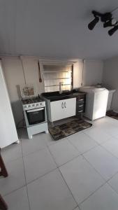 a small kitchen with a stove and a refrigerator at Casa Grey in Cambará