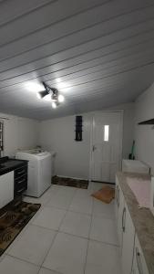 a large white kitchen with a ceiling fan in it at Casa Grey in Cambara do Sul
