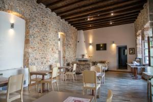 a restaurant with tables and chairs and a stone wall at Trapela Areopolis, Boutique Hotel in Areopoli