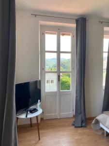 a room with a door and a table with a television at Maison Bric in Millesimo