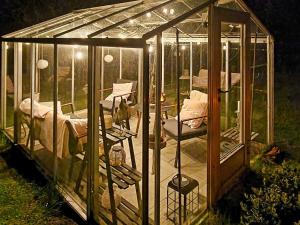 a green house with beds in it in the grass at 6 person holiday home in L derup in Löderup