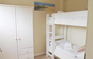 ein Schlafzimmer mit einem Etagenbett und einem Schrank in der Unterkunft Gorgeous Home In Dagebll With Kitchen in Dagebüll