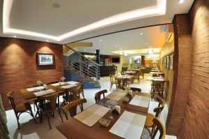 um restaurante com mesas e cadeiras de madeira e uma escadaria em Rothenburg Hotel em Nova Petrópolis