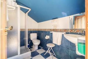 La salle de bains bleue et blanche est pourvue de toilettes et d'un lavabo. dans l'établissement CASA DE VERDES Turismo Rural, à San Pelayo