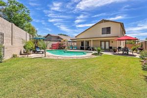 un patio trasero con piscina y una casa en Spacious Phoenix-Area Escape with Pool and Hot Tub, en Avondale