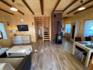 a living room with wooden floors and a fireplace at Lawendula domek nad Miedwiem in Morzyczyn