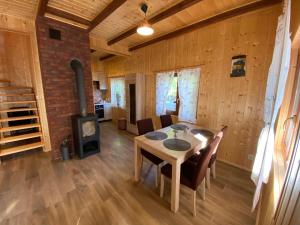 a dining room with a table and a wood stove at Lawendula domek nad Miedwiem in Morzyczyn