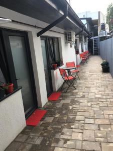 un patio avec des chaises et des tables rouges dans un bâtiment dans l'établissement Casa David, à Constanţa