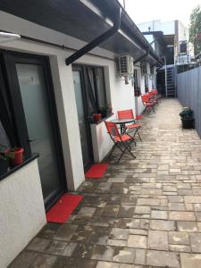 un patio con sedie rosse e tavoli su un edificio di Casa David a Constanţa