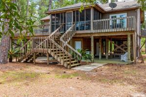 a large house with stairs leading up to it at Coronado Cove Cottage in Dauphin Island