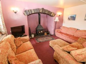 a living room with a couch and a fireplace at Glan y Gors in Dinorwic
