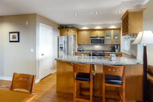 a kitchen with a granite counter top and wooden cabinets at Trappers Crossing 22 in Big White