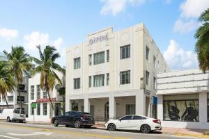 un edificio blanco con dos coches estacionados frente a él en South Beach Two Bedroom Apartment, en Miami Beach