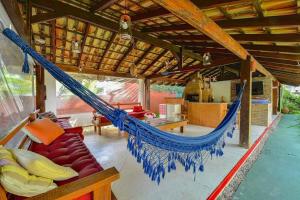 a hammock in the middle of a house at VELINN Pousada Villa Caiçara in Ilhabela