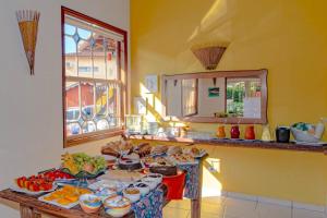 una cocina con una mesa con comida. en VELINN Pousada Villa Caiçara, en Ilhabela