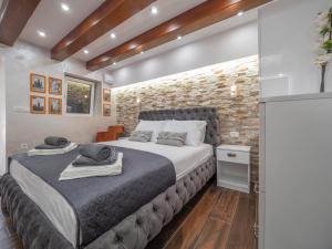 a bedroom with a large bed and a brick wall at Luxury Boutique Studio in Budva