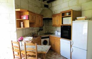 a kitchen with a table and a white refrigerator at Nice Home In Chinon With 2 Bedrooms And Wifi in Chinon