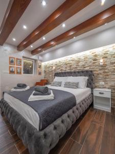 a large bed in a room with a brick wall at Luxury Boutique Studio in Budva