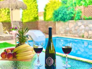 een tafel met twee glazen wijn en een schaal fruit bij Villa Katerina in Stalida