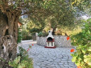 a stone walkway with a fireplace in a garden at Gran Domenica Villa Corfu, Private Pool, Sea View, Garden in Nisaki