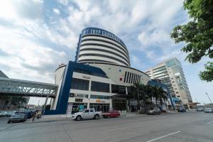 un grand bâtiment avec des voitures garées devant lui dans l'établissement TRYP by Wyndham Guayaquil Airport, à Guayaquil