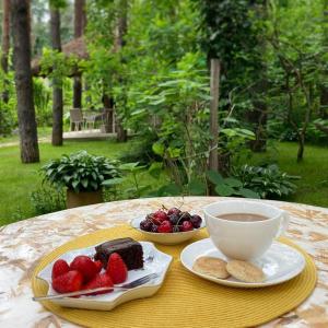 a table with two plates of food and a cup of coffee at Vila Dunavski Raj in Golubac