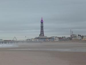 a view of the beach with the lighthouse in the background at Roachvale - Couples & Families - Room only in Blackpool