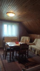 a dining room with a table and chairs and a couch at Bosaca apartment in Žabljak