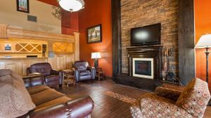 a living room with leather furniture and a fireplace at Best Western Tower West Lodge in Gillette