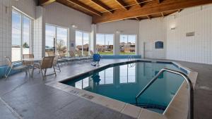 una piscina en un edificio con mesa y sillas en Best Western Holiday Manor, en Newton