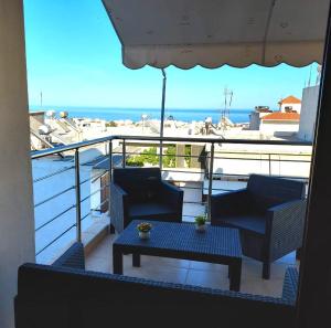 een balkon met 2 stoelen en een tafel en de oceaan bij Luxury Summer Escape in Rhodes in Rhodos-stad