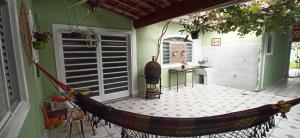 a porch with a hammock in a house at Casa do Aconchego Espaçosa e Arejada in Caraguatatuba