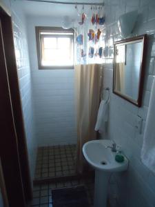 uma pequena casa de banho com um lavatório e uma janela em Pousada Vó Irene em Itacuruçá