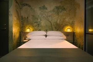 a bed with four pillows on it in a bedroom at Ode in Toronto